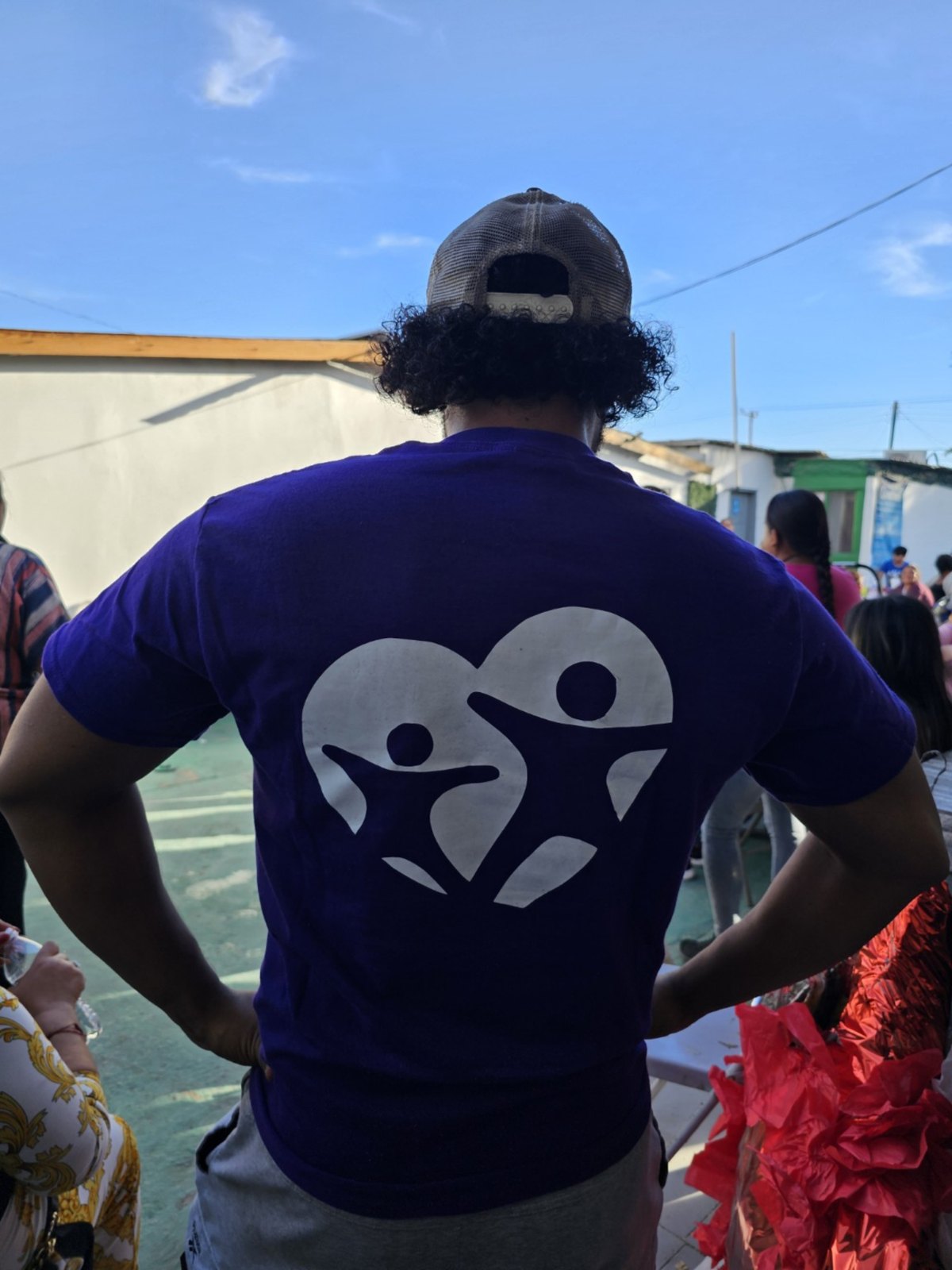 Volunteer wearing Happy Homes Foundation shirt with logo on back